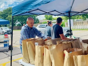 Senator Scott Hill visits Salina YMCA to volunteer at Grab N’ Go food event during record-breaking week